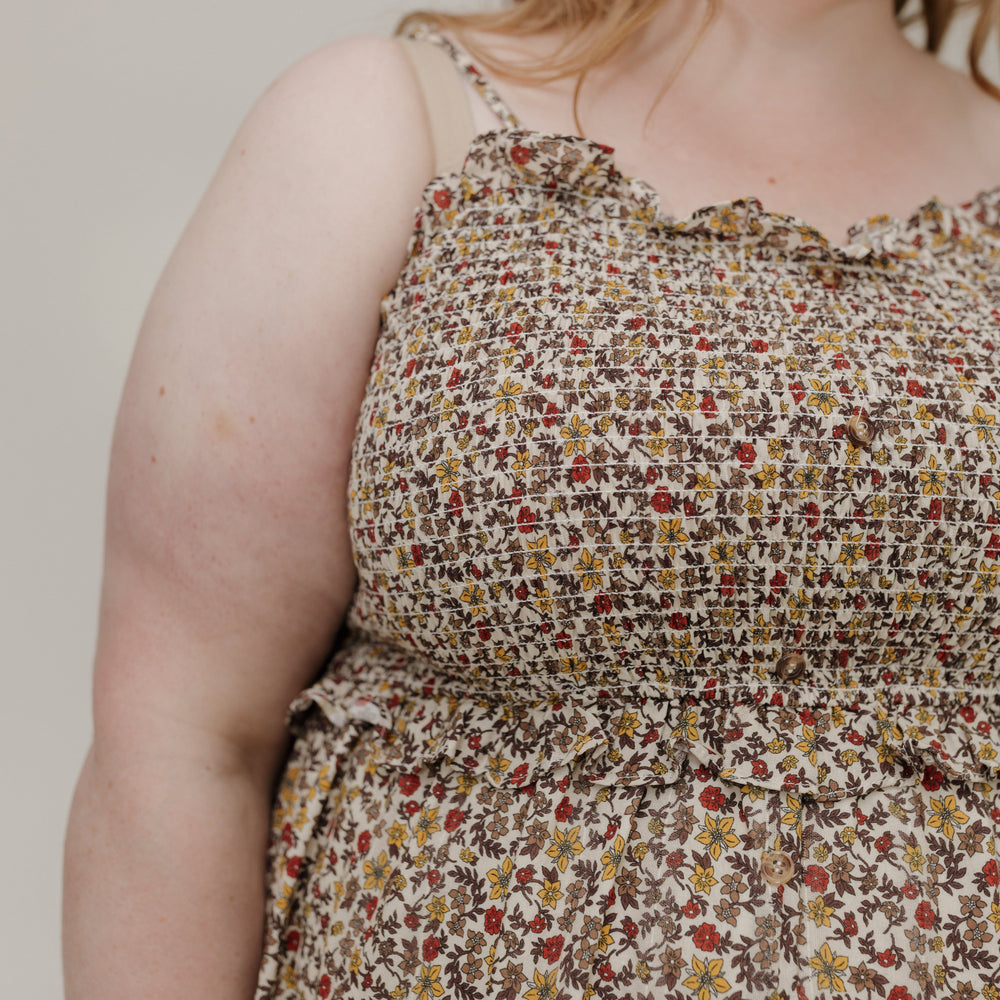 Person wearing a floral dress with a neutral background