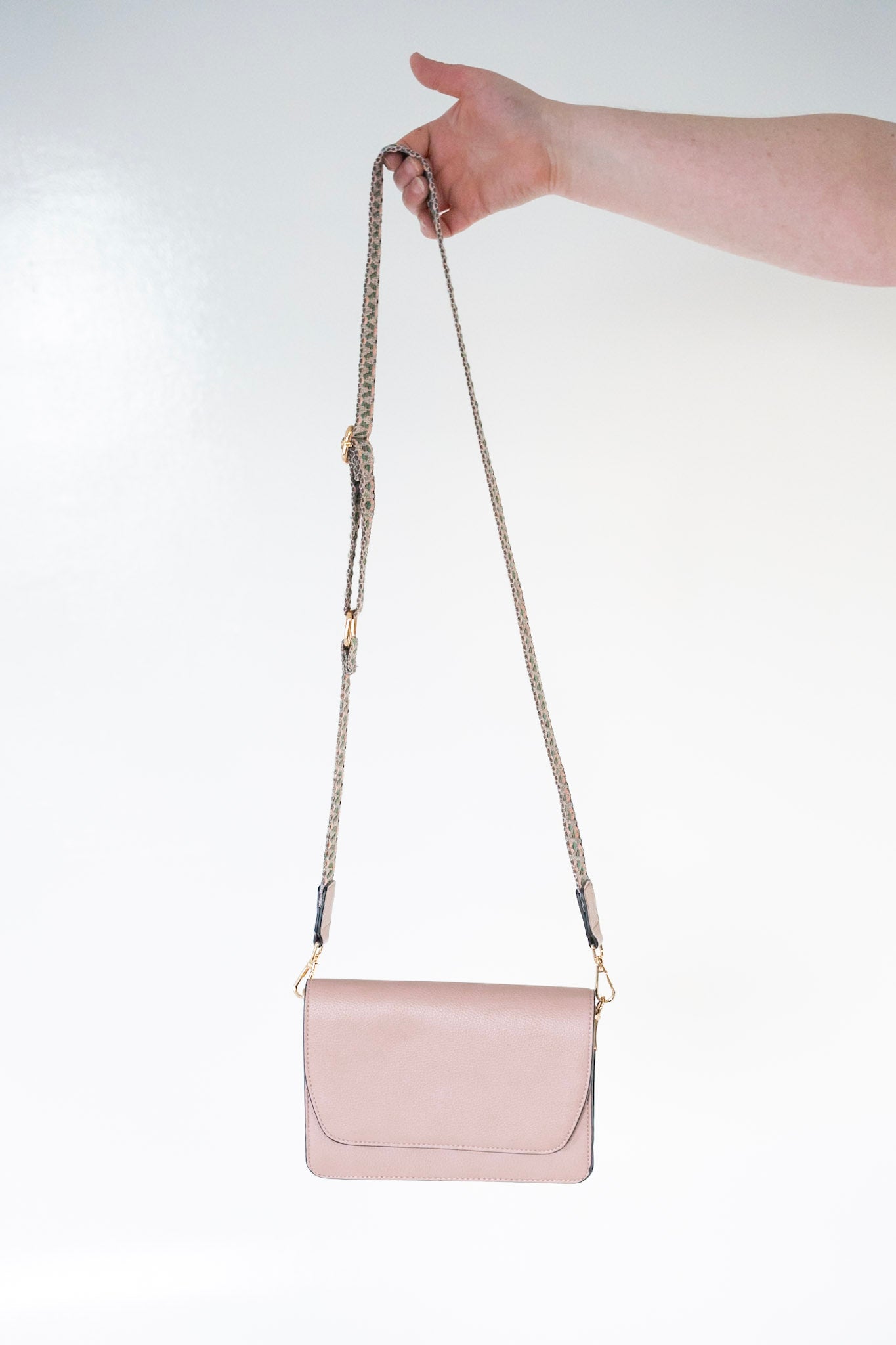 FLAP-OVER CROSSBODY WITH GUITAR STRAP IN ASH ROSE
Pink rosy purse with geometric woven knit strap