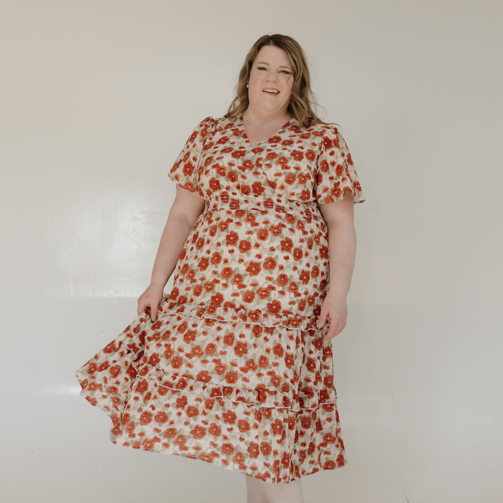 Woman wearing a floral dress against a plain background