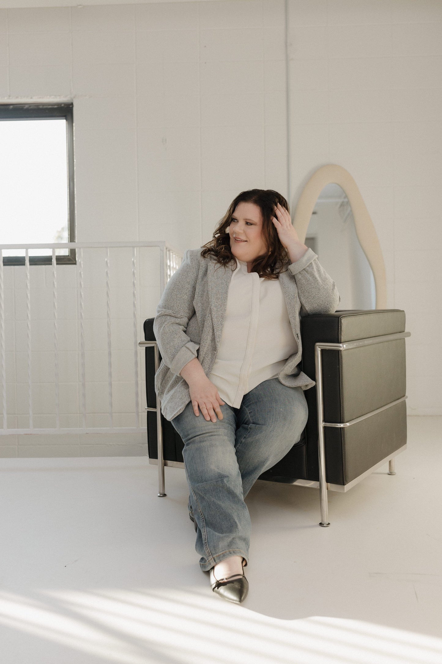 Woman sitting on a modern chair in a minimalistic room