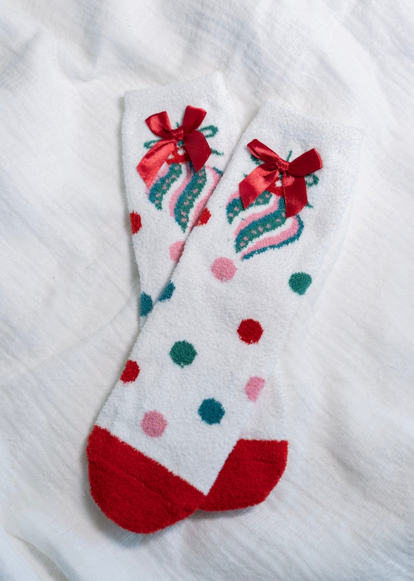 White sock with colorful polka dots and red bows on a white background