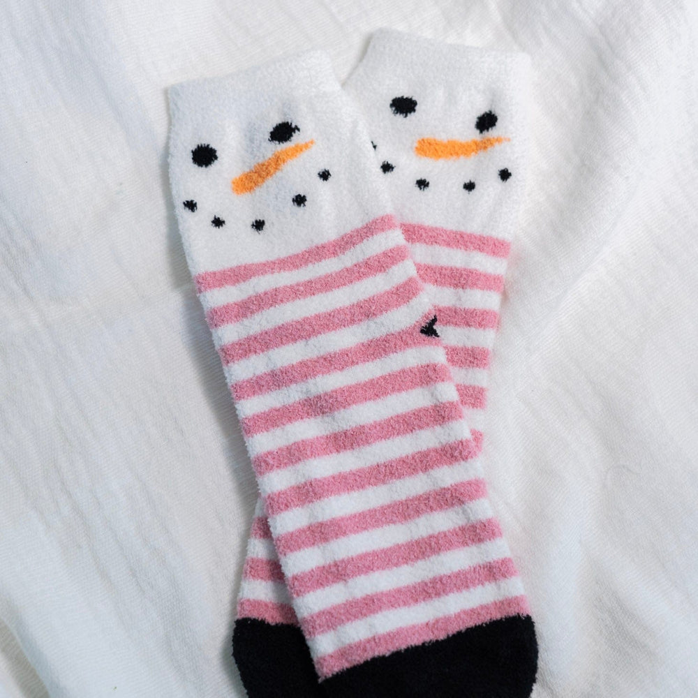 Pink and white striped socks with snowman design on a white textured background