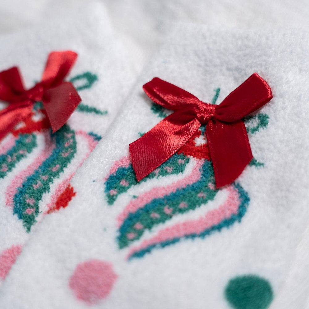 Close-up of a white fabric with red bows and colorful patterns on a white background