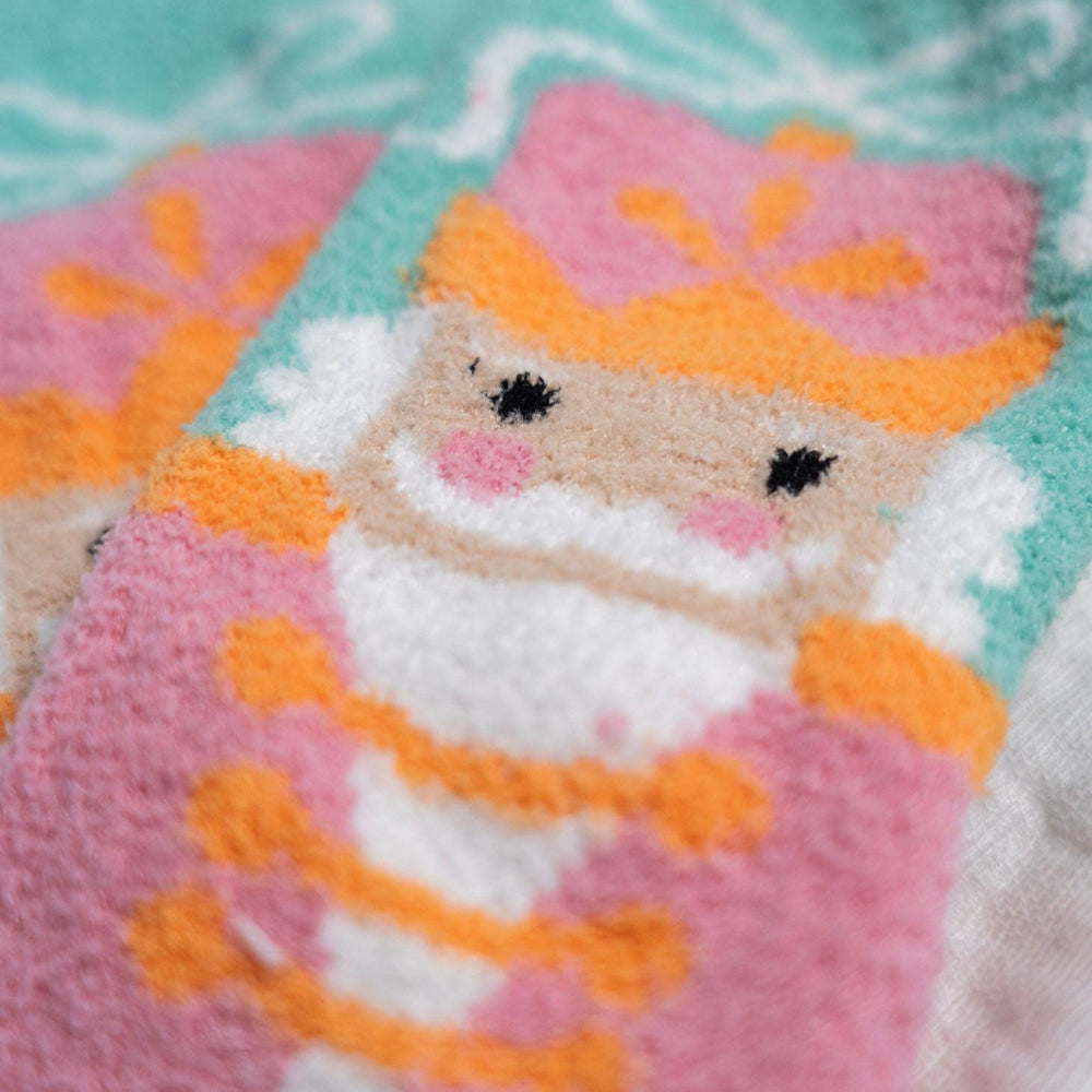 Knitted socks with a nutcracker character design on a light blue background