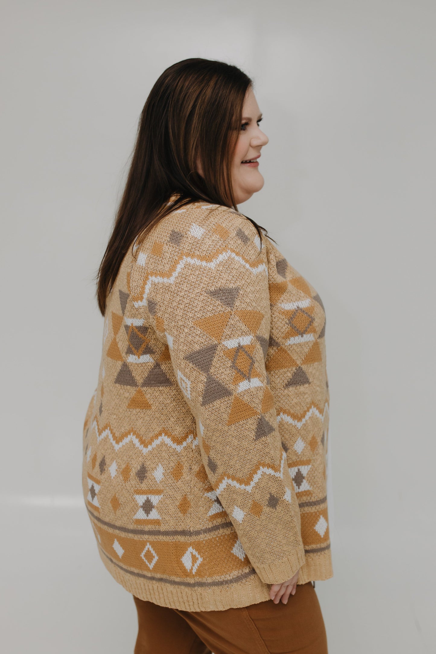 Woman wearing a patterned sweater against a plain background