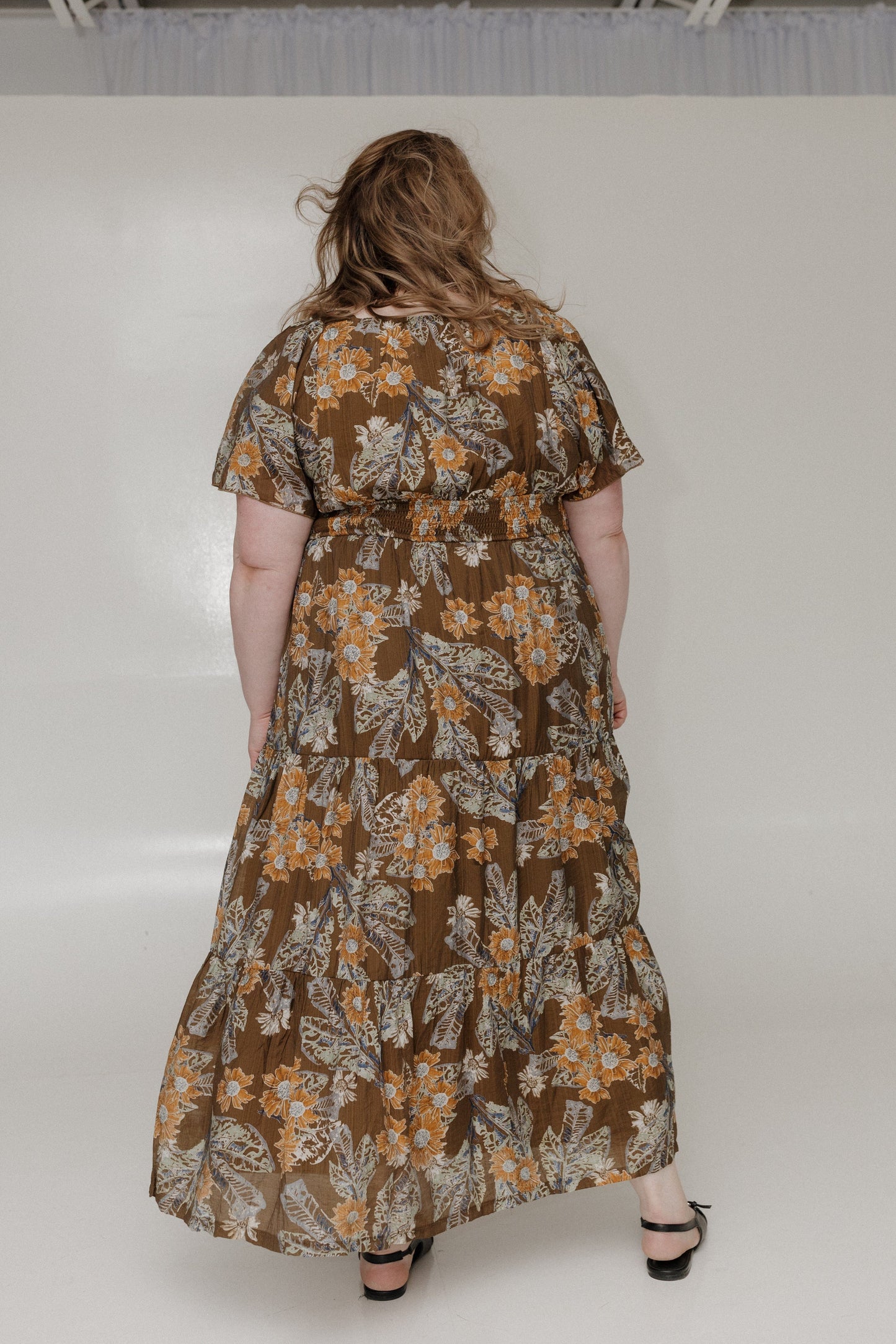 Woman wearing a floral dress with a plain background