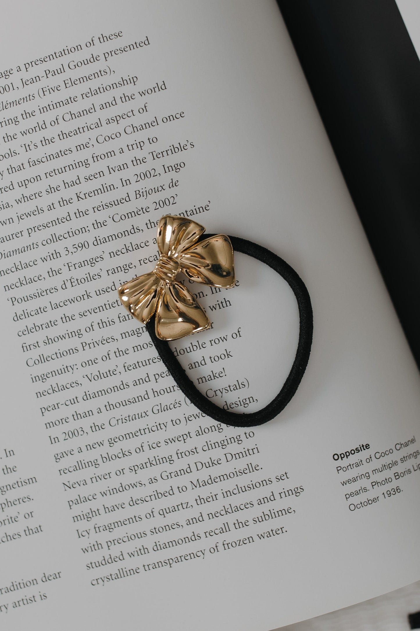Gold bow hair tie on a book page