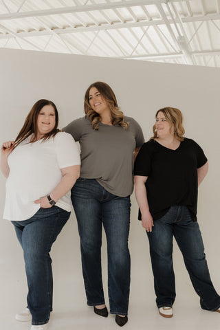 Three women standing together against a white background