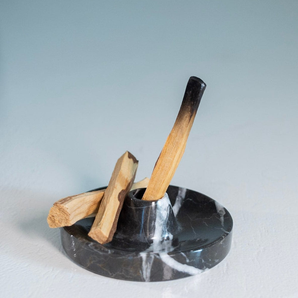 Marble ashtray with wooden matches on a light gray background