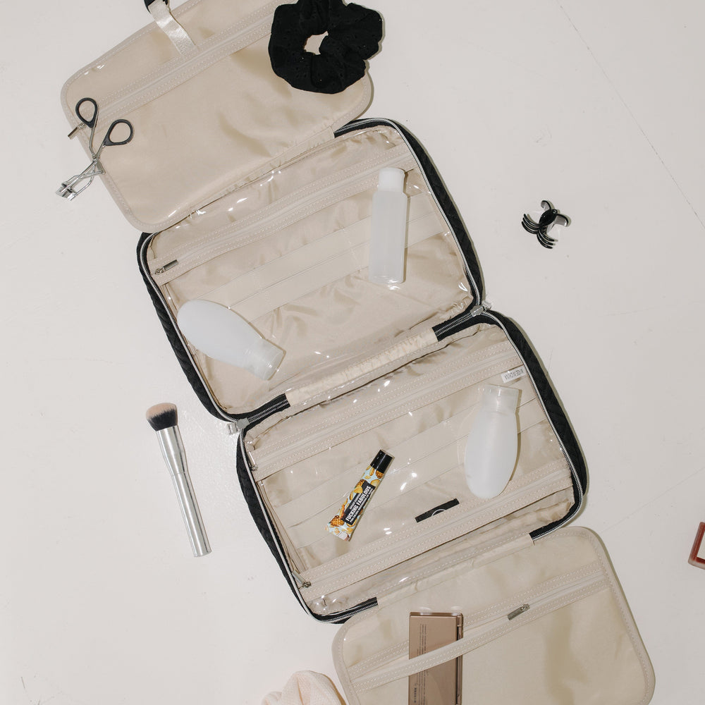 Open beige travel case with cosmetic items on a white background