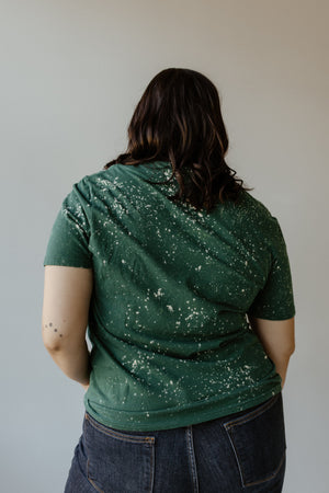 A person with long hair stands with their back facing the camera, wearing the "HARVEST YOUR HAPPINESS" graphic tee by Love Marlow and jeans, capturing the essence of fall fashion.