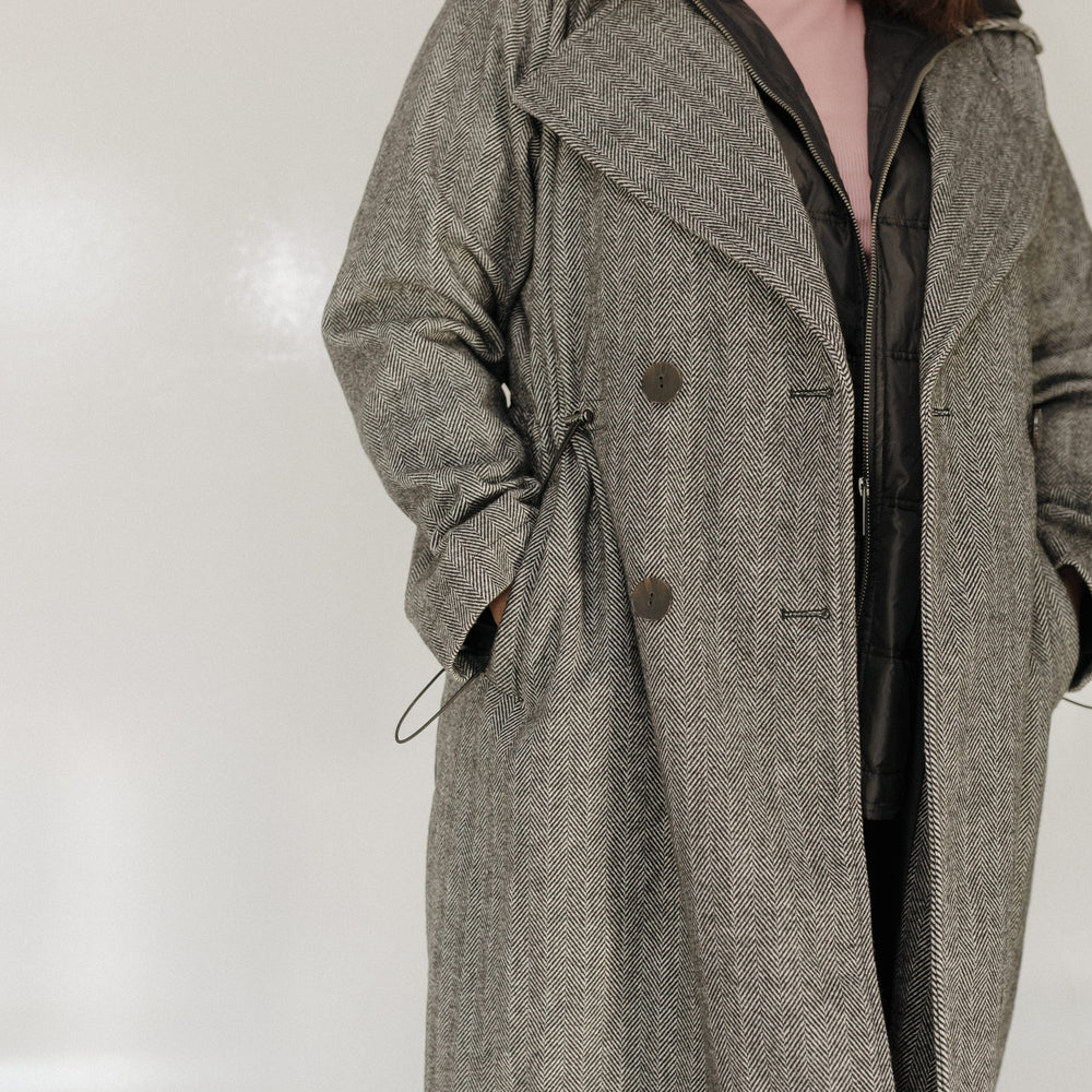 Person wearing a gray coat with a white background