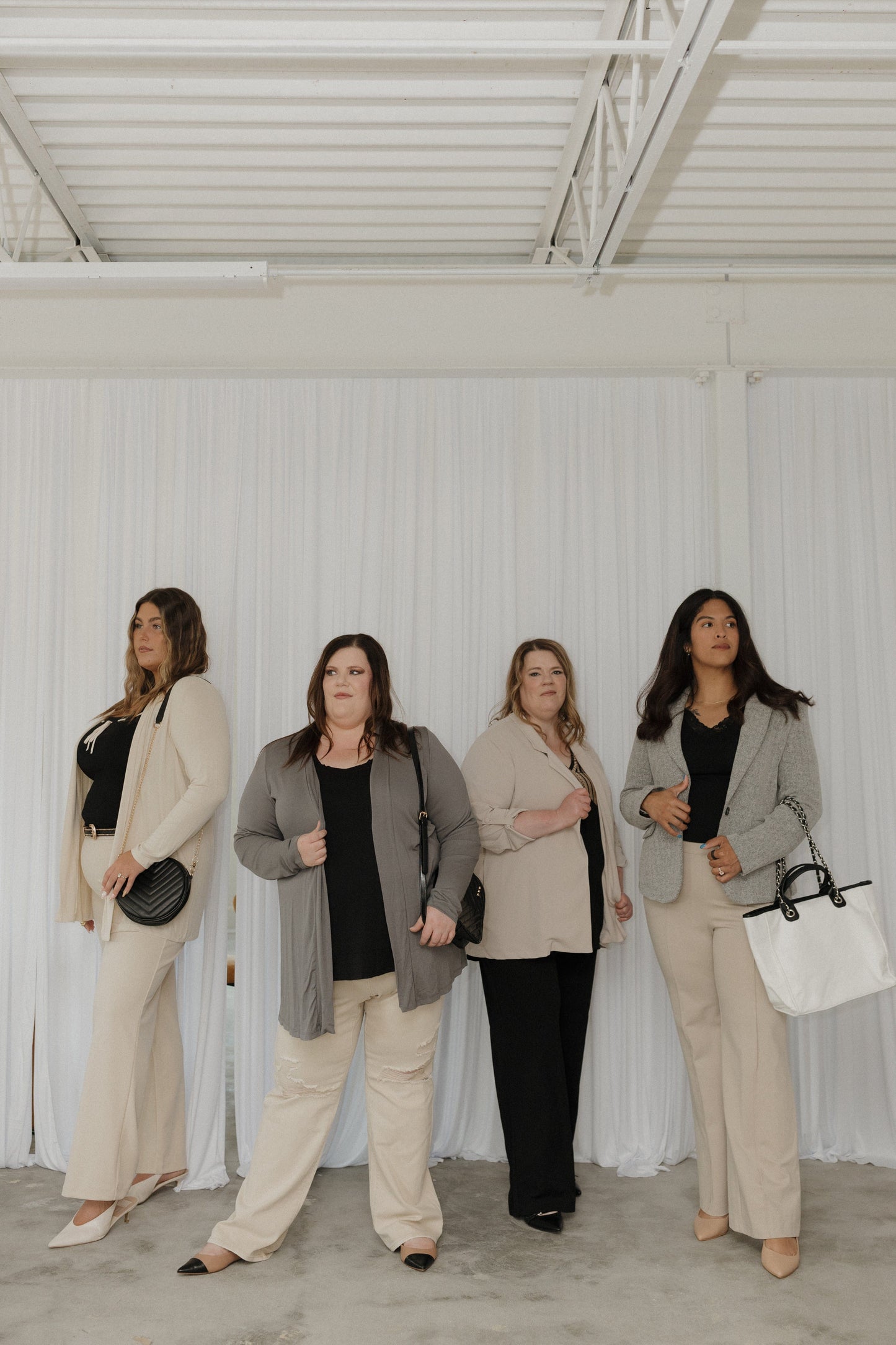 Four women standing in a row against a white background