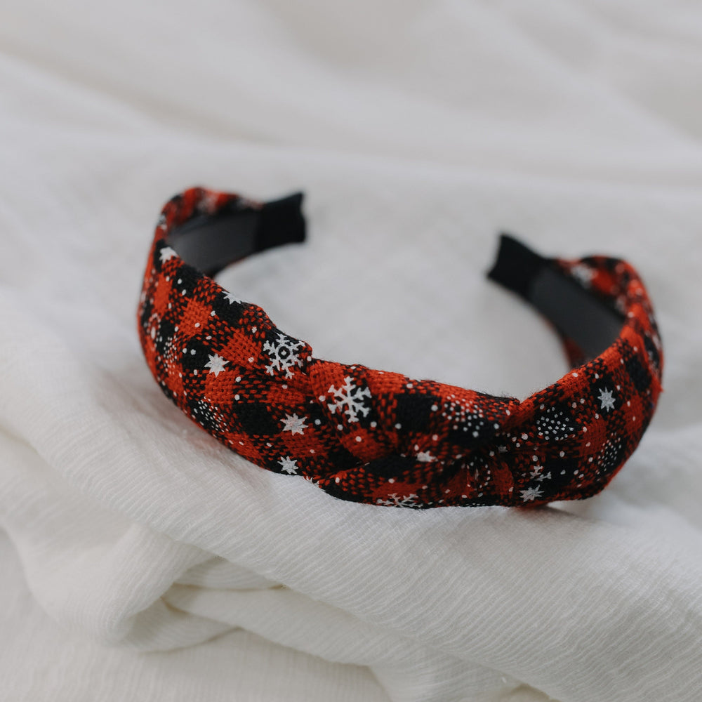 Red and black patterned headband on a white fabric background