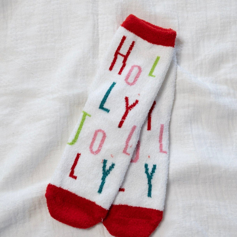 White socks with colorful text 'HOLLY JOLLY' on a white fabric background