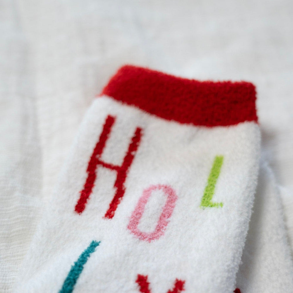 White socks with colorful letters spelling 'HOLLY' on a white background