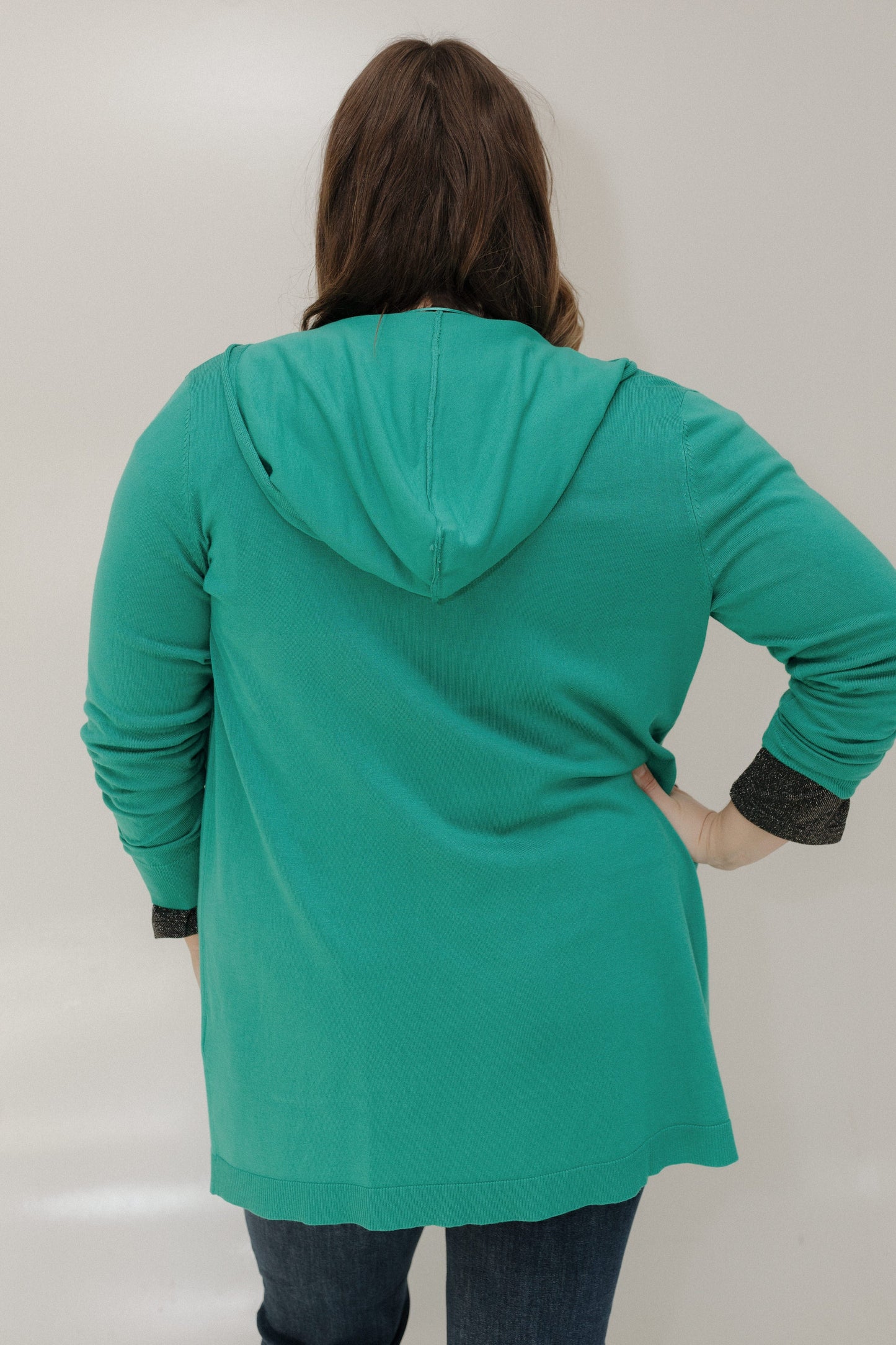 Person wearing a teal hoodie with a plain background