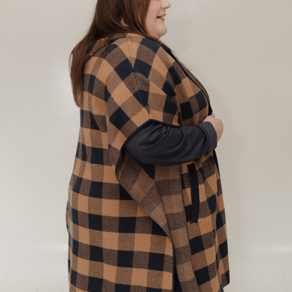 Person wearing a checkered vest over a dark long-sleeve shirt against a plain background