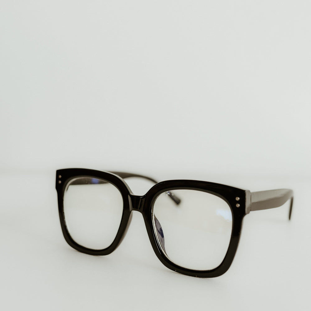 Black eyeglasses on a light gray background