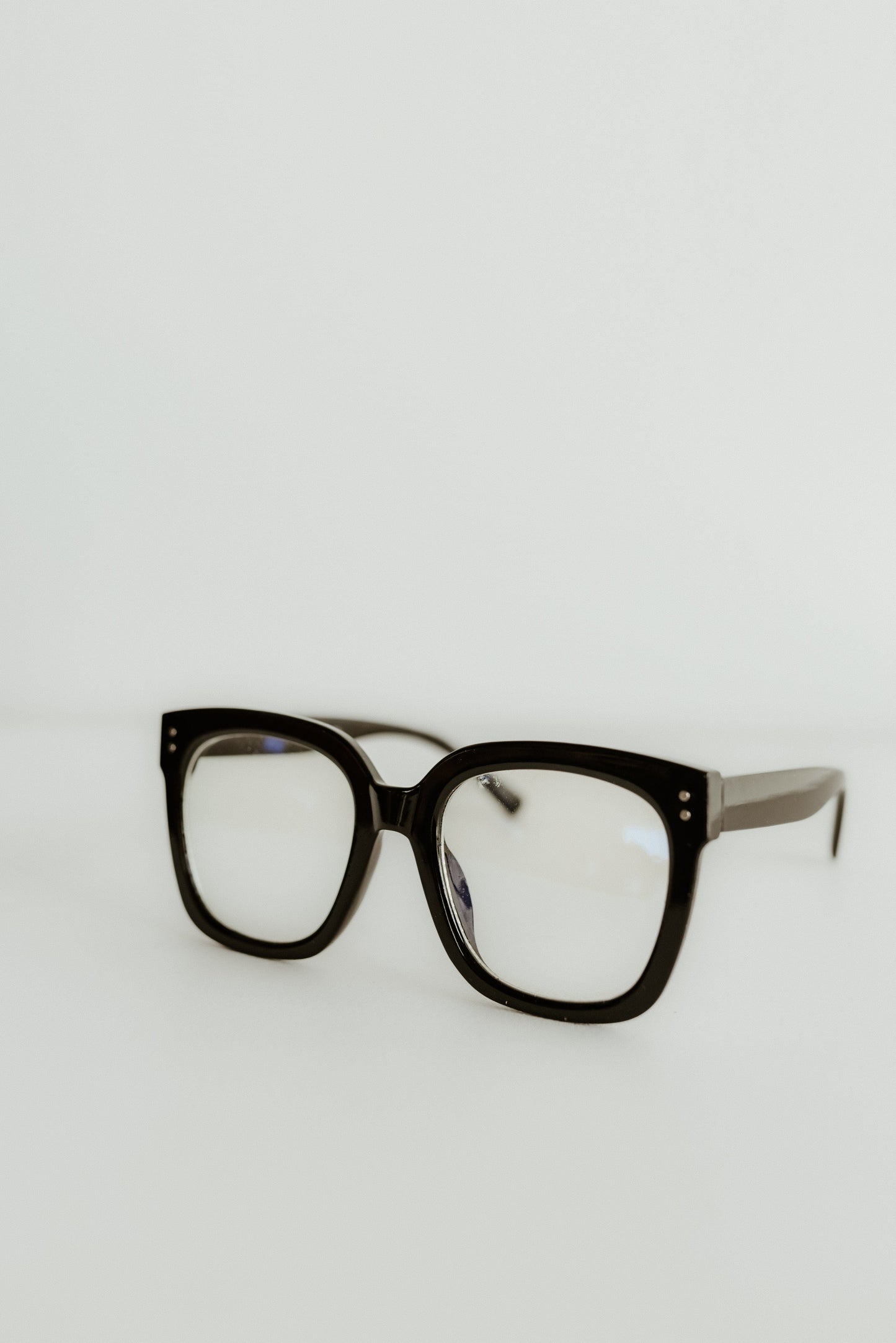 Black eyeglasses on a light gray background