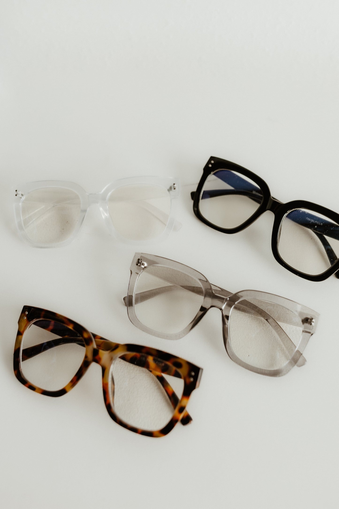Four pairs of eyeglasses with different frames on a white background
