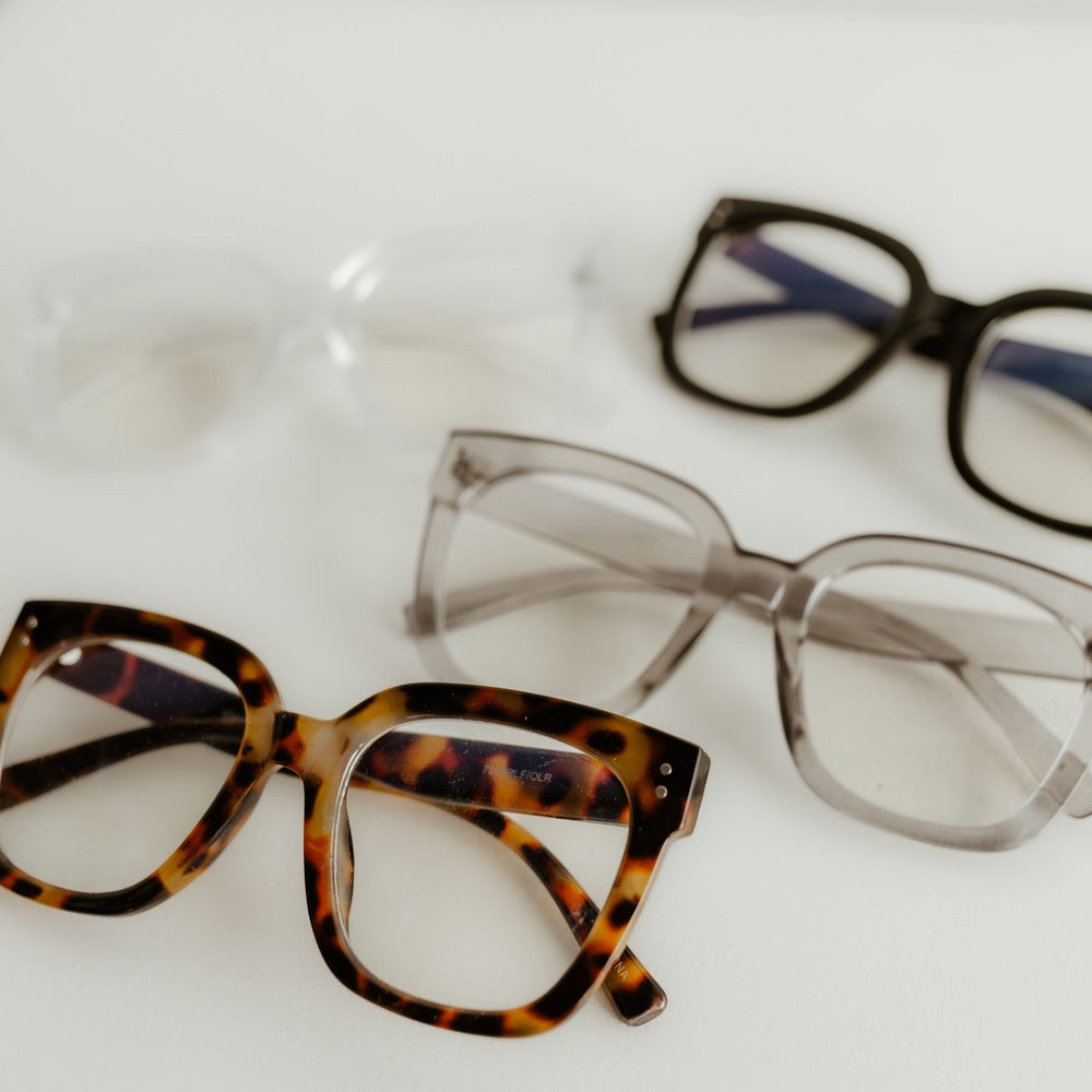 Three pairs of eyeglasses with different frames on a white background