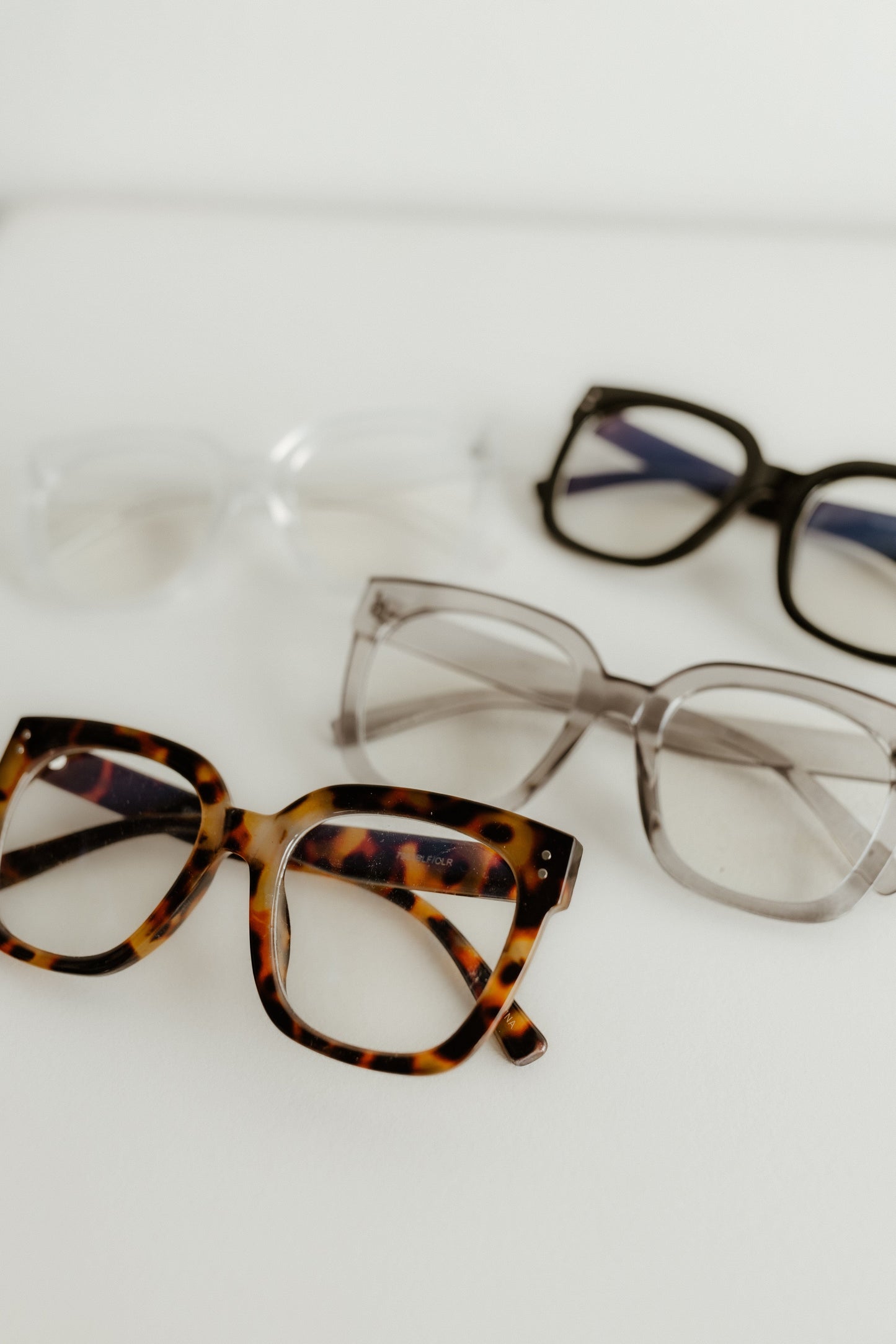 Three pairs of eyeglasses with different frames on a white background