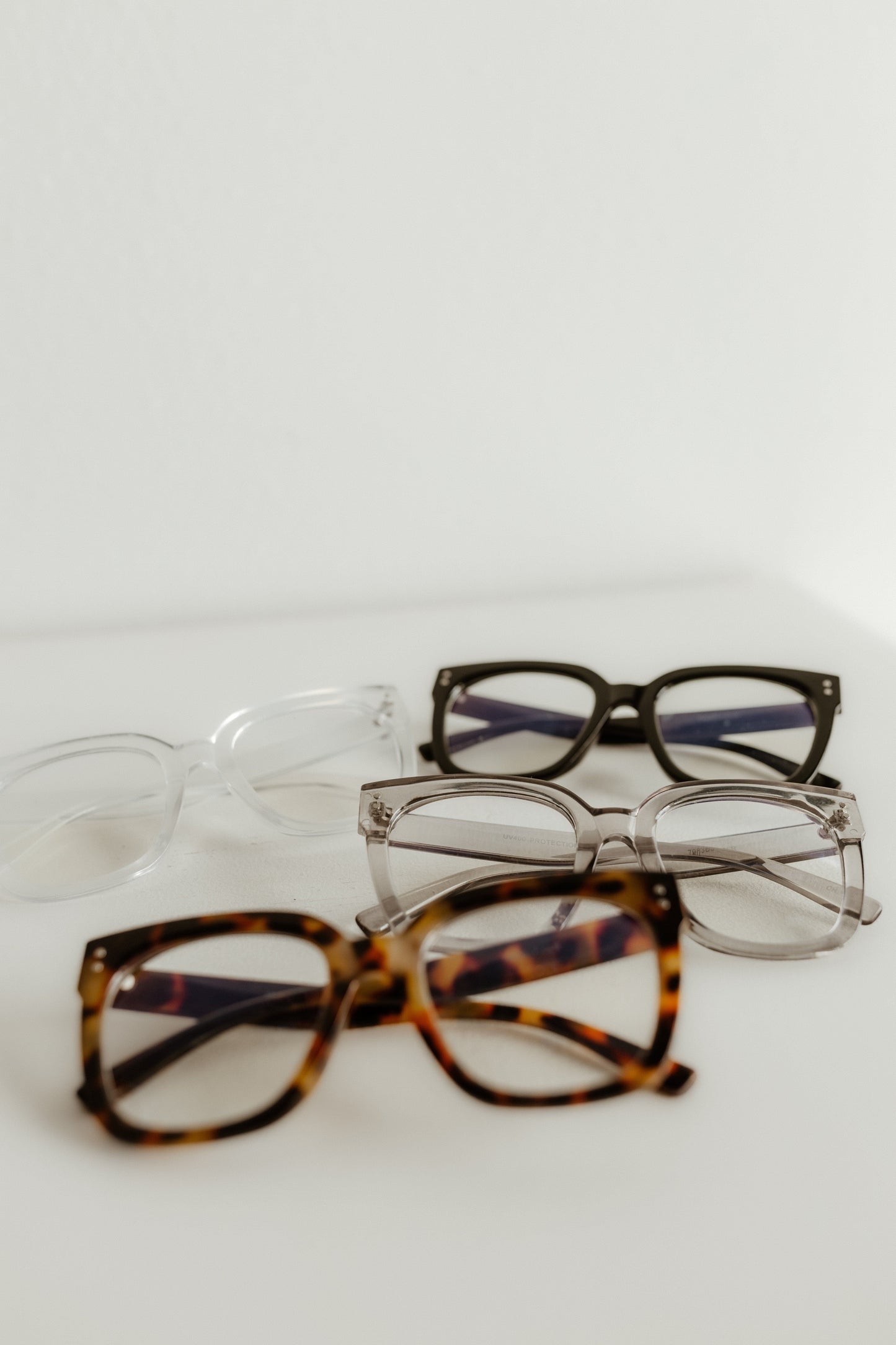 Four pairs of eyeglasses with different frames on a white background