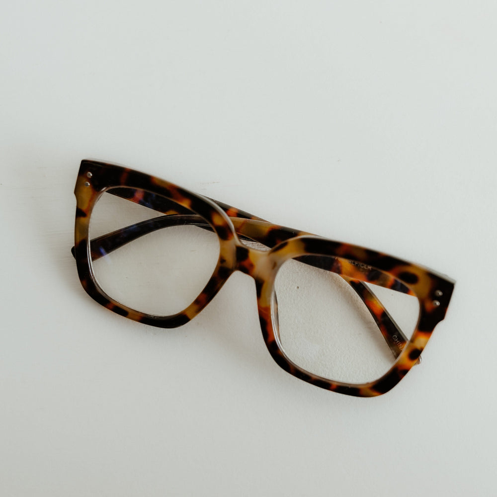 Tortoiseshell cat-eye glasses on a light gray background