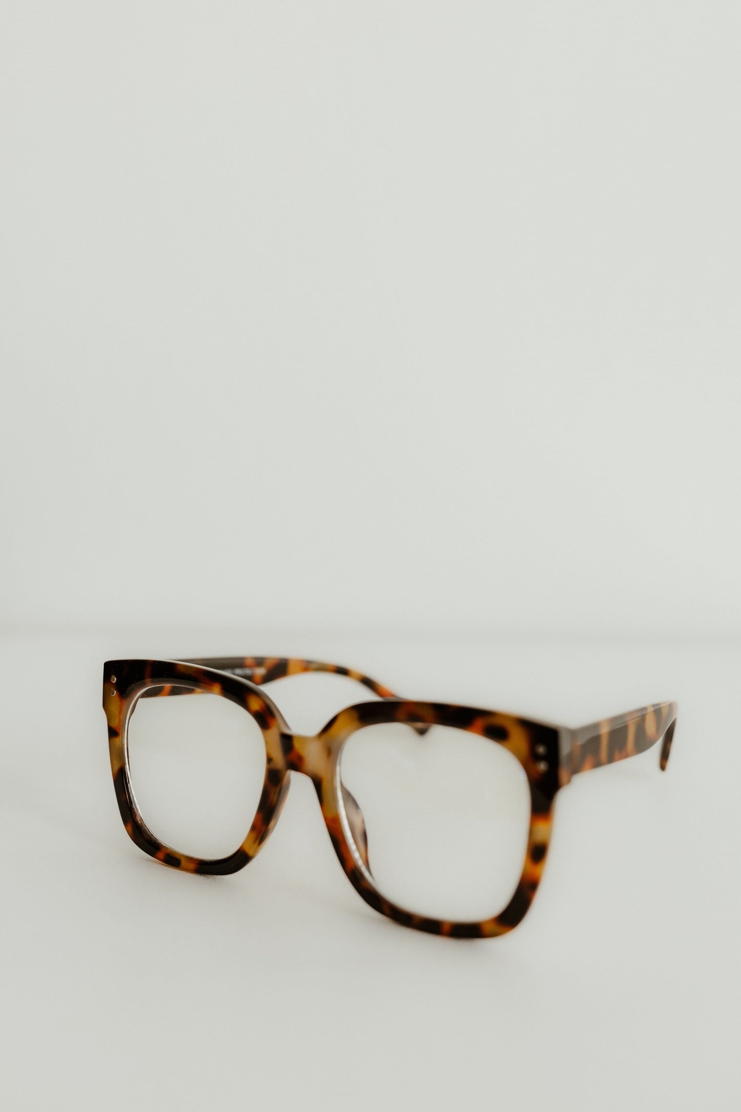 Tortoiseshell glasses on a light gray background