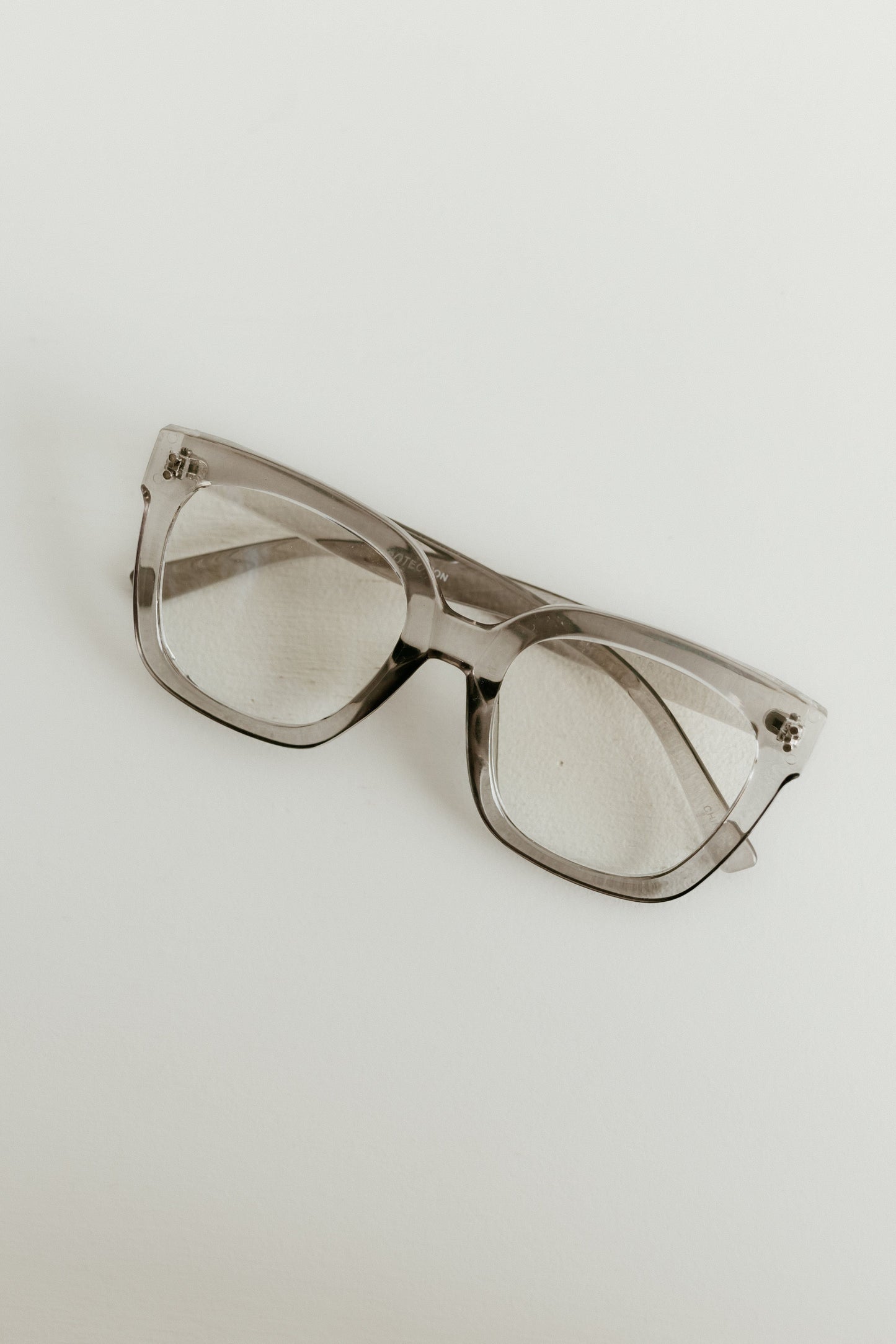 Clear sunglasses on a light gray background