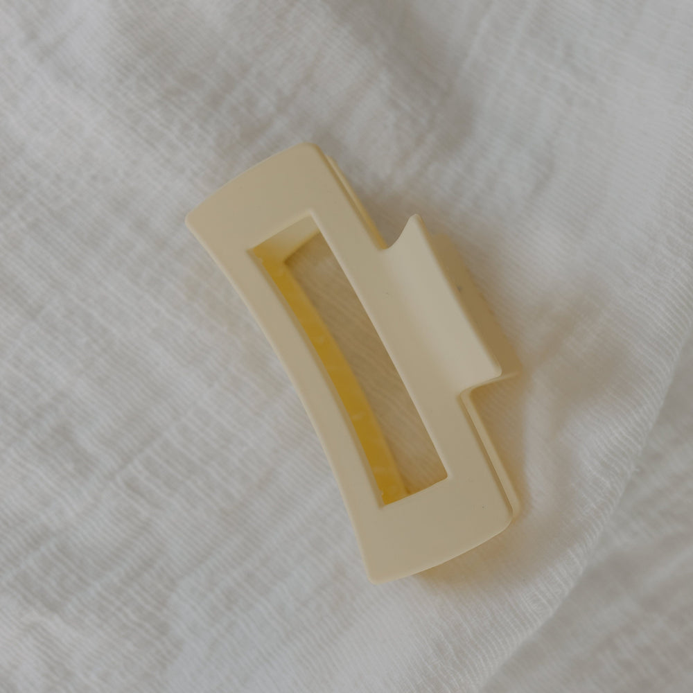 Ivory rectangular claw clip on a textured white fabric background