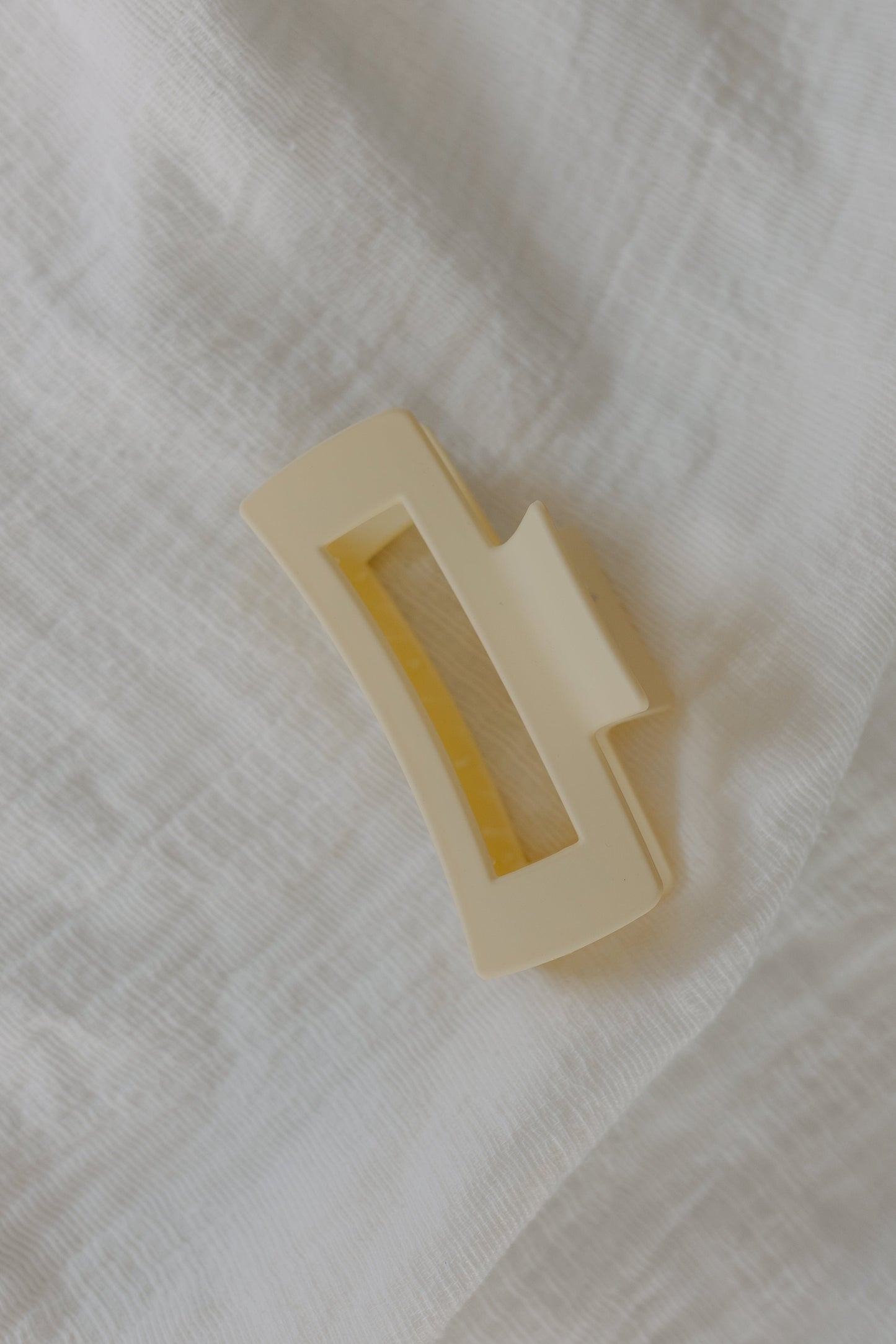 Ivory rectangular claw clip on a textured white fabric background
