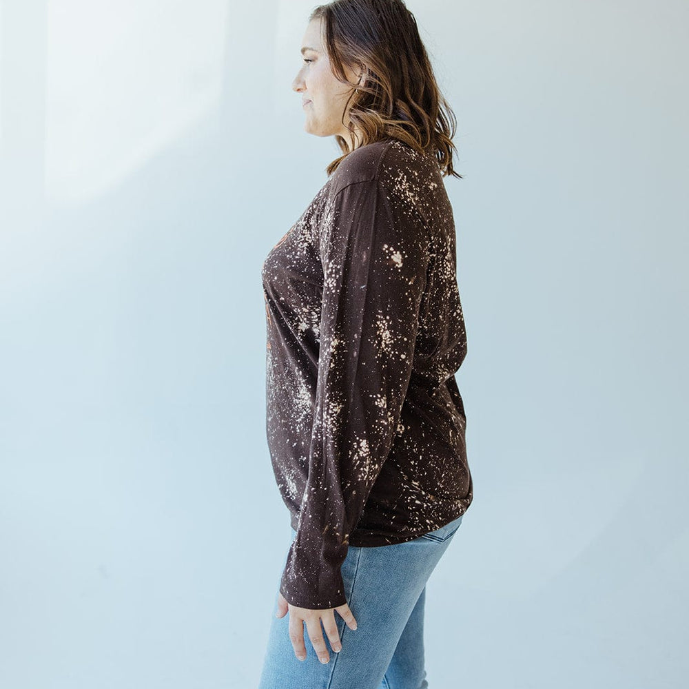 A woman stands in profile against a light background, wearing the "I LIKE MY ATTITUDE HOW I LIKE MY PUMPKINS WITH EXTRA SPICE" long-sleeve tee by Love Marlow and blue jeans.
