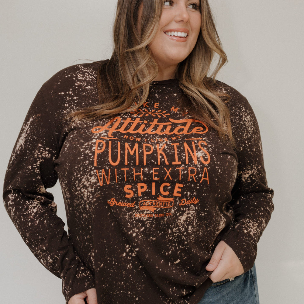 "I LIKE MY ATTITUDE HOW I LIKE MY PUMPKINS WITH EXTRA SPICE" LONG-SLEEVE TEE Love Marlow
Woman wearing a distressed brown sweatshirt with text, standing against a plain background