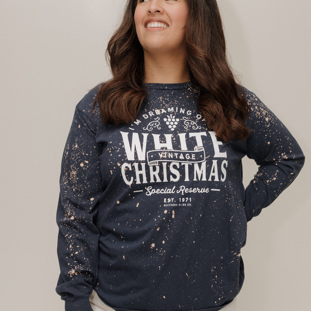 Woman wearing a navy sweatshirt with 'White Christmas' text against a plain background