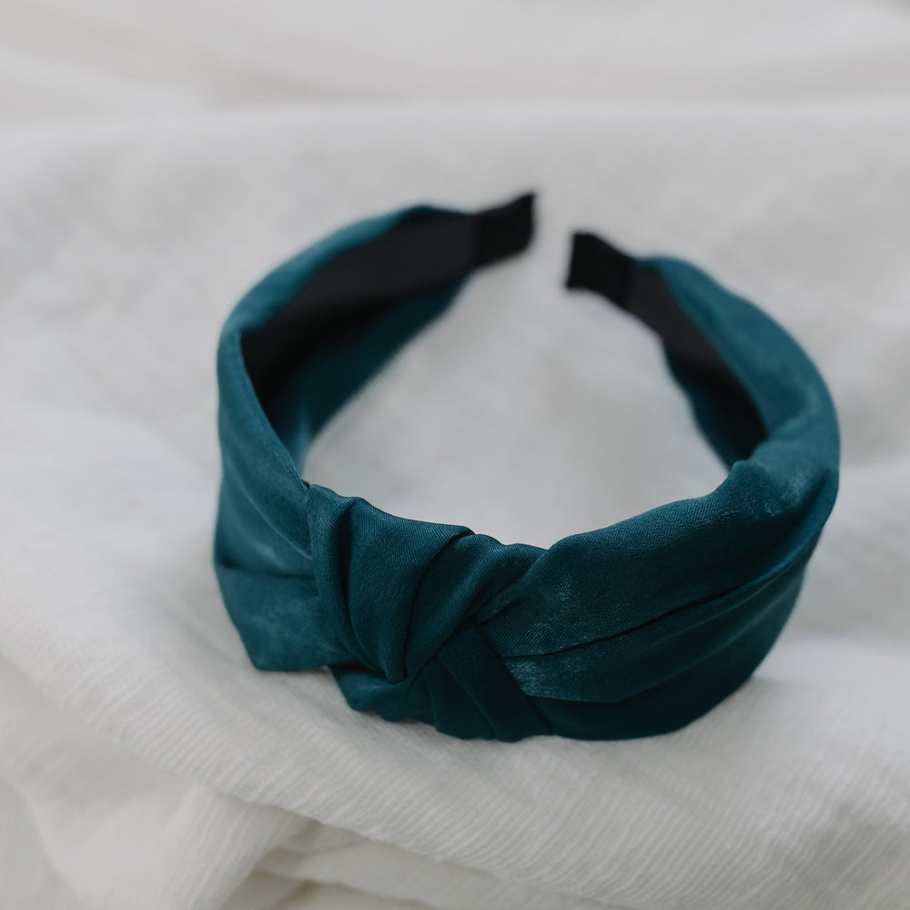 Teal headband on a white fabric background