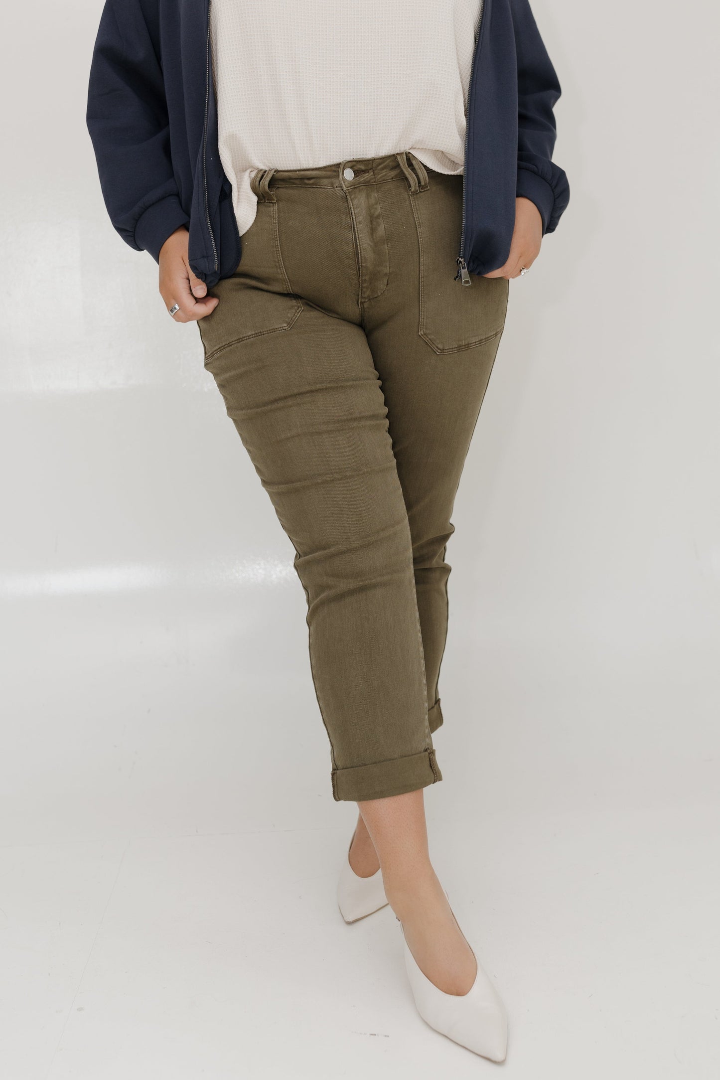 Person wearing olive green pants with a white background