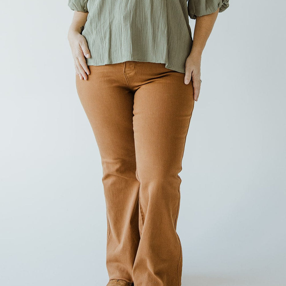 Person wearing a green blouse and Judy Blue High Waist Tummy Control Flare jeans in Urban Bronze, standing against a plain background.