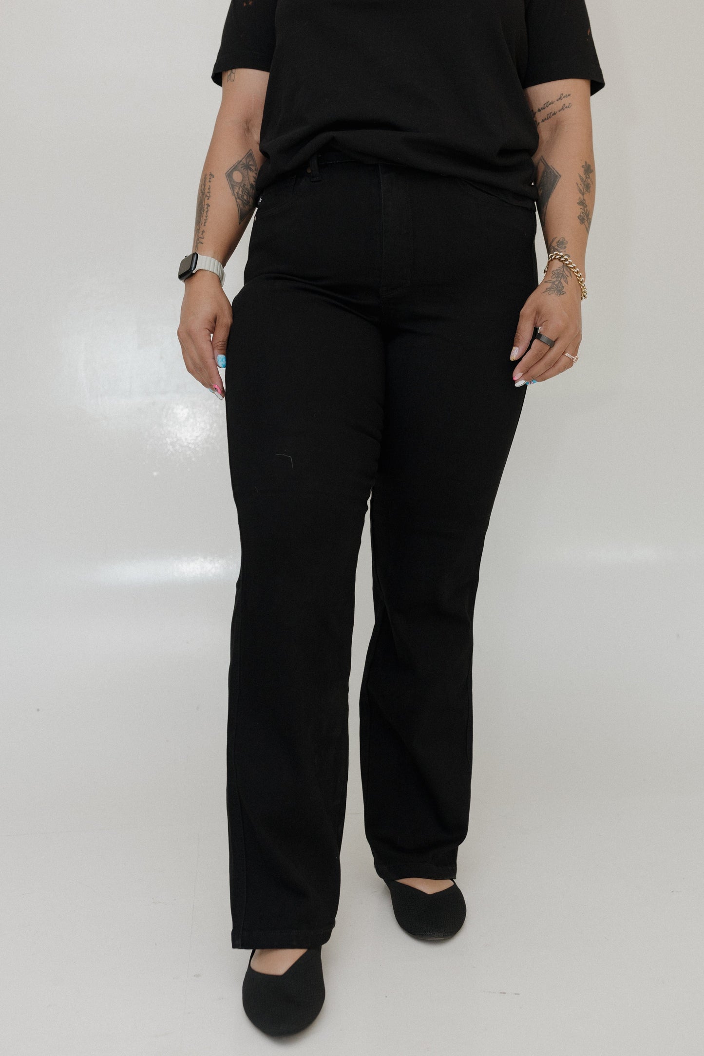Person wearing black pants and a black top on a white background