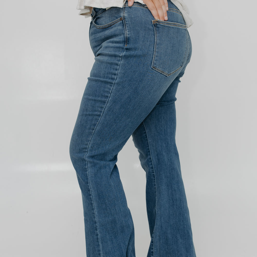 Person wearing blue jeans on a plain background