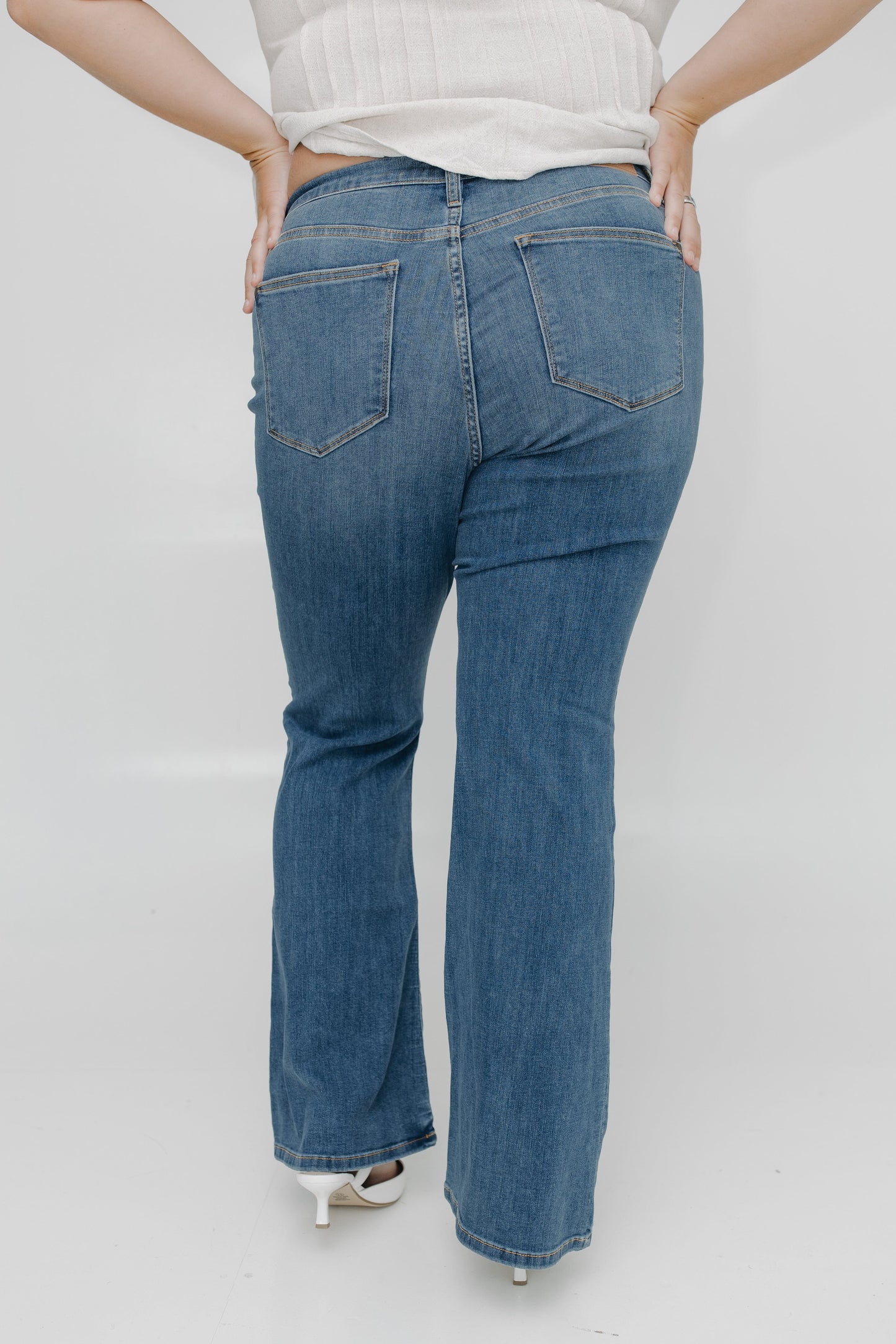 Person wearing blue jeans on a plain background