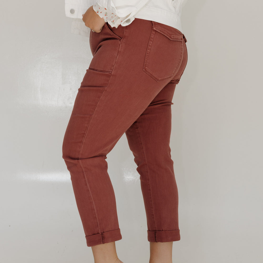 Person wearing red pants and a white top on a plain background