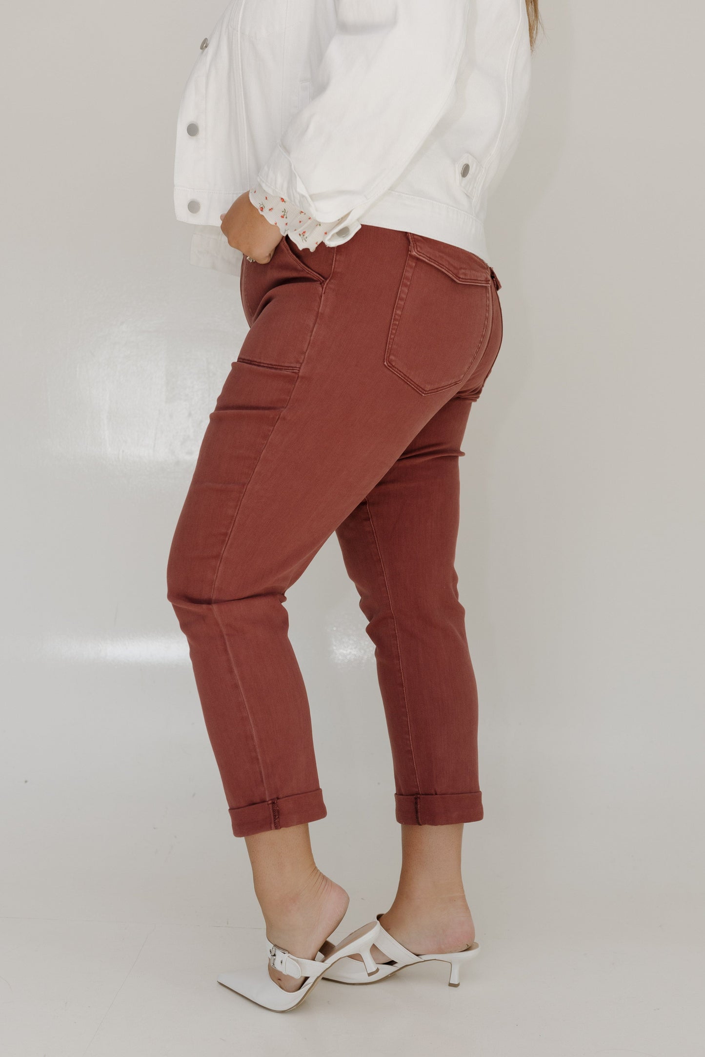 Person wearing red pants and a white top on a plain background