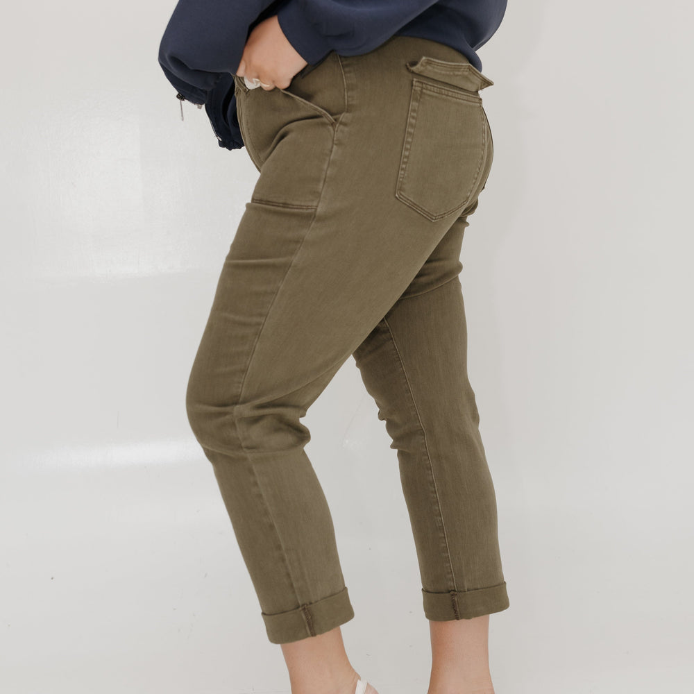 Person wearing olive green cargo pants and a navy sweatshirt on a white background