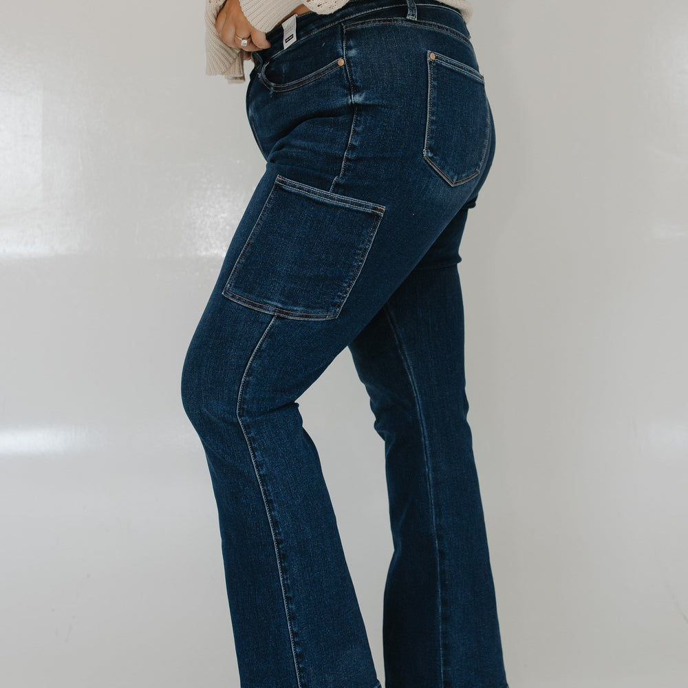 Person wearing blue jeans and a beige sweater on a white background