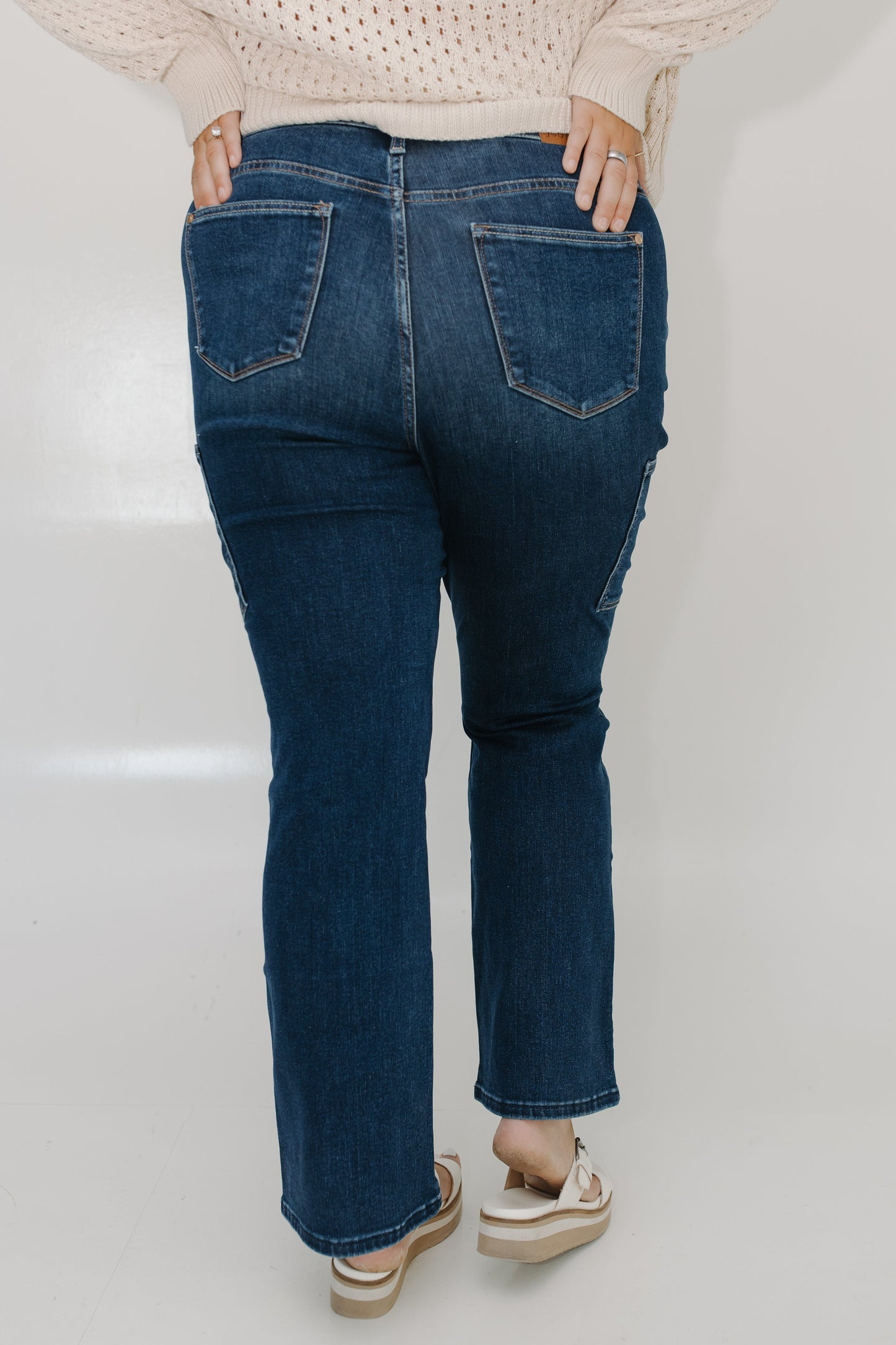Person wearing blue jeans on a plain background