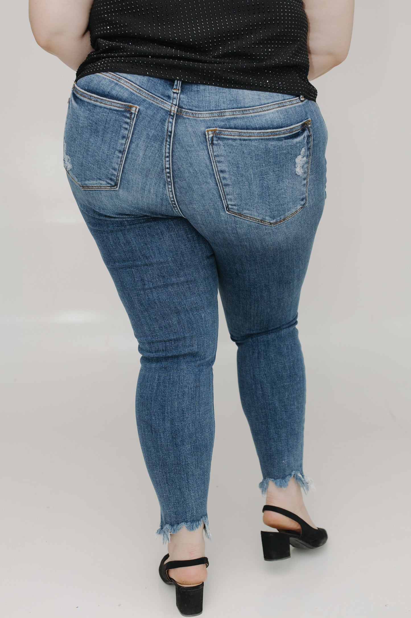 Person wearing blue jeans on a plain background