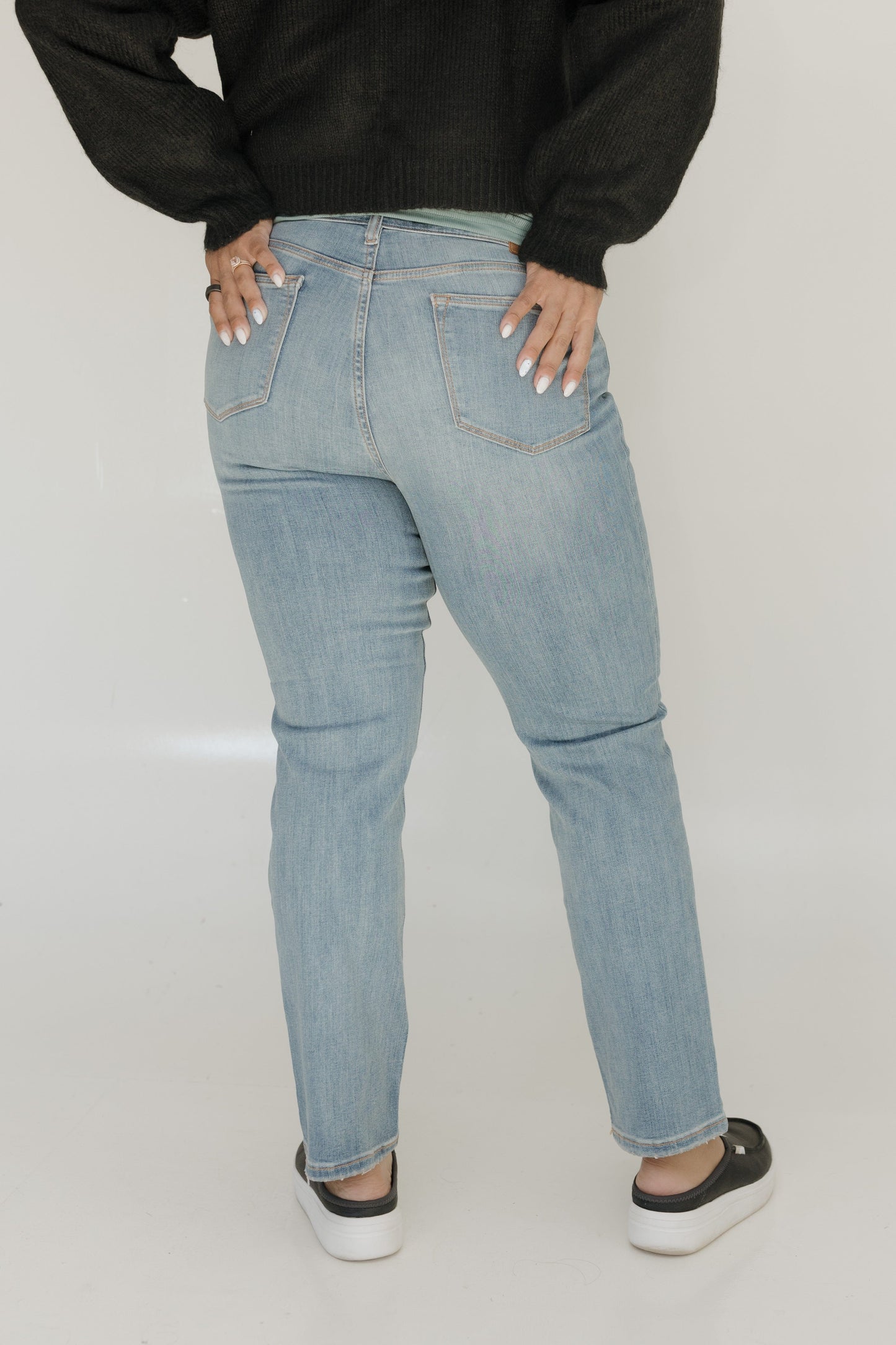 Person wearing light blue jeans on a plain background