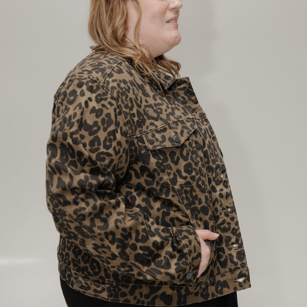 Person wearing a leopard print jacket against a plain background